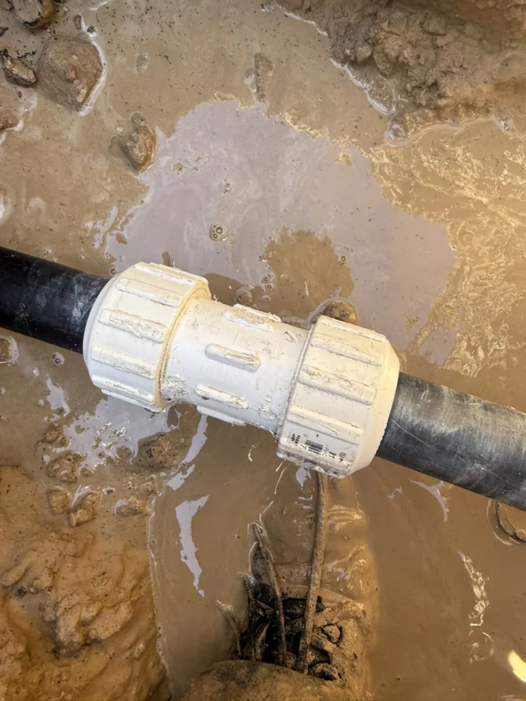 Exposed underground water pipe and fitting at a Keystone main-service leak repair